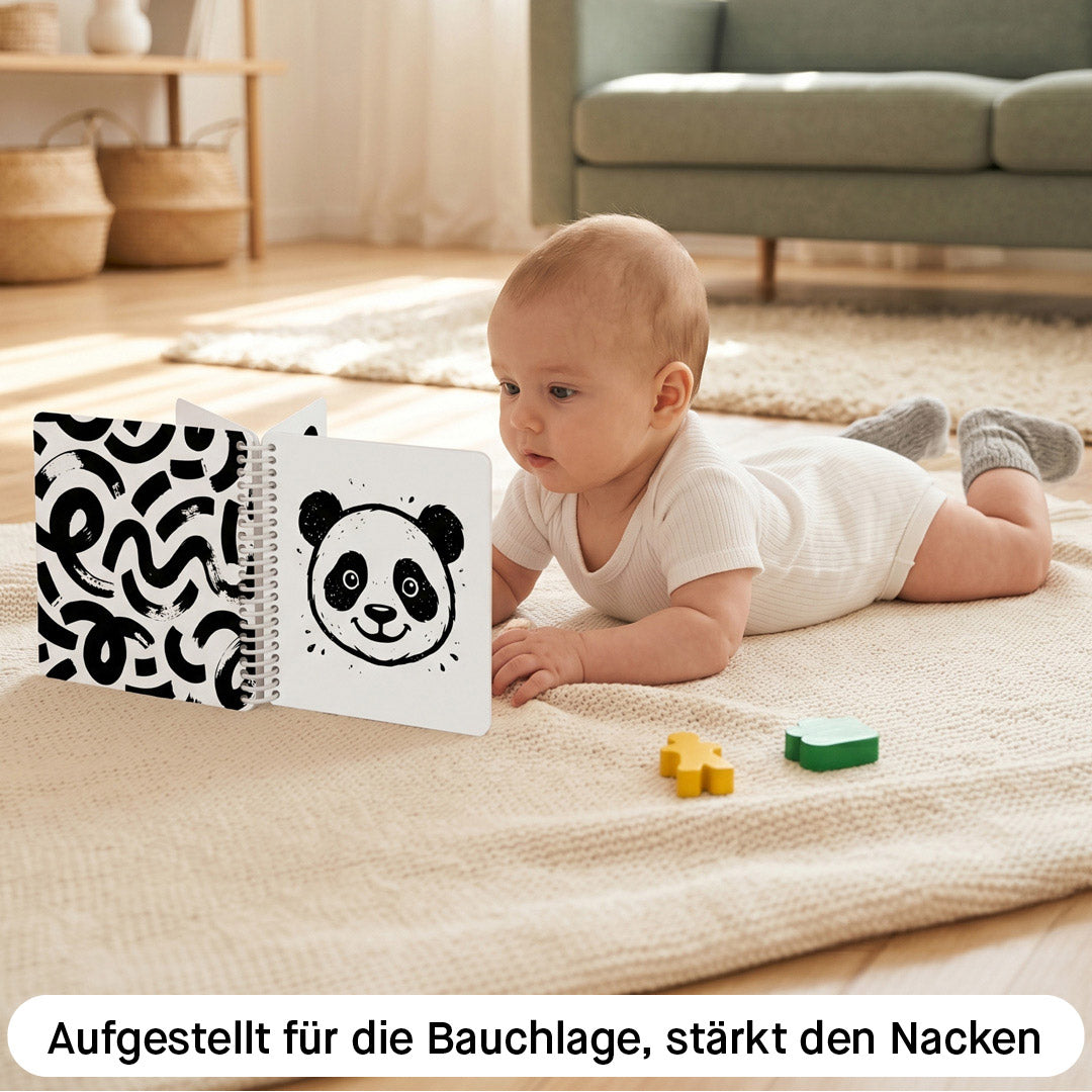 Kontrastbuch aufgestellt für die Bauchlage, Baby hebt den Kopf und schaut auf die Schwarz-Weiß-Illustration eines Pandas, Kleine Prints