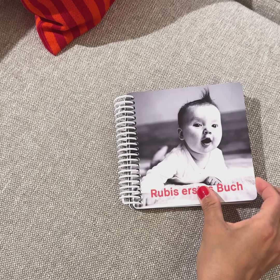 Kontrastbuch für Babys mit schwarz-weiß Illustrationen und Babyfoto wird durchgeblättert, Kleine Prints